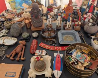 Example of trinkets and memorabilia available including matchbooks, carved sculptures, and toys.