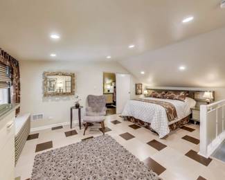 Bedding, rug, armchair with ottoman and side table with orchid plant are for sale.