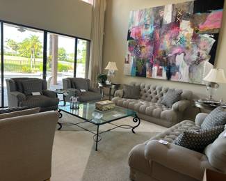 Photo of living room two chairs two sofas , cocktail table, artwork end tables and lamps