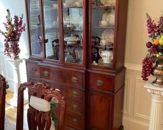 China Cabinet /Desk as top drawer opens and drops down for lap top with glass front doors for books or china. dining chair, column with brass floral and fruit arrangement, china, crystal, and rug