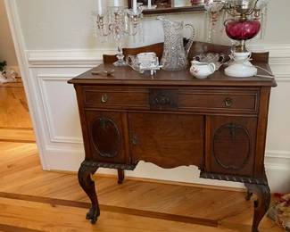 antique claw foot side board, crystal candelabra area rug and mirror.