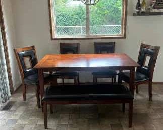 Dining room table set with four chairs and one bench