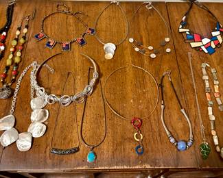 A collection of costume and silver necklaces. 