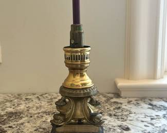 Brass Candlestick Table Lamp | Antique brass candlestick table lamp with intricate scrollwork, a dark marble base, and a purple candle. - h. 10 x w. 3.5 in