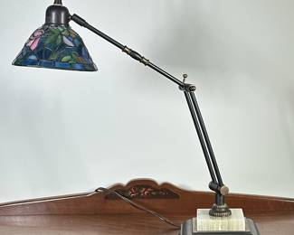 Tiffany Style Desk Lamp | Tiffany-style desk lamp, featuring a stained glass lamp shade with a floral pattern, and an adjustable arm for directing light. -
h. 21.5 x w. 14 x d. 6 in