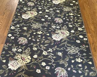 Area Rug - White Floral on Dark Green | Vintage area rug with white floral details on a dark green/black background. - w. 41 x l. 76 in