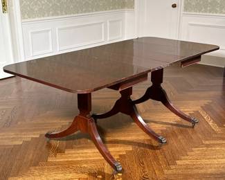 Duncan Phyfe Style Dining Table with Leaves | Vintage Duncan Phyfe style three pillar mahogany dining table with two drop leaf ends, four removable leaves, and metal claw feet. Without leaves: l. 30" - h. 30 x w. 76 x d. 36 in (With