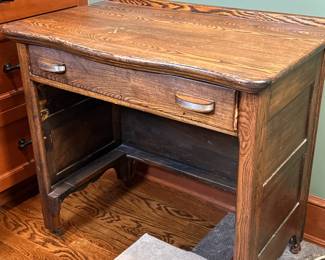 Small Single Drawer Desk | Vintage wooden desk with a single drawer featuring two pull handles, set on caster wheels and possibly once fitted with a bottom shelf. - h. 29.5 x w. 33 x d. 19 in