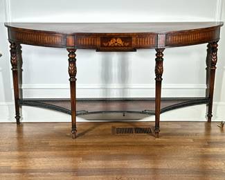 Theodore Alexander Demilune Console Table | Vintage (20th century) Theodore Alexander carved mahogany demilune tiered console table with marquetry inlay details, a center drawer and a brass gallery wall on the lower tier. - h. 34 x l. 70 x d. 18 in