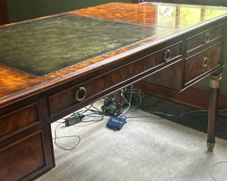 Theodore Alexander "Missives To A Friend" Desk | Theodore Alexander (High Point, North Carolina) "Missives To A Friend" desk, crafted in flame mahogany (top) and mahogany (bottom), features a rectangular leather-inset top above five drawers flanking the kneehole, all supported by turned, brass-leaf-mounted tapering legs. sides pull out x each8.5 - h. 30 x w. 60 x d. 30 in