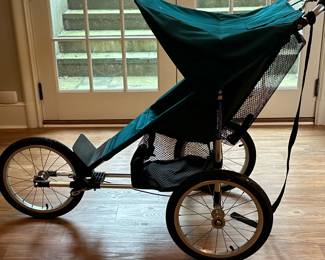 Baby Jogger Jogging Stroller | Baby Jogger jogging stroller on three wheels, with green canopy and seat.
Wheels need air.