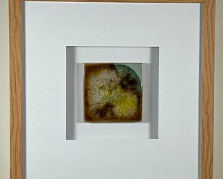 Abstract Artwork - Geode | Square abstract artwork (print) in a white frame, featuring an artist rendition of a geode-like object with rich brown, yellow, and subtle blue tones that resemble crystallized formations or bubbling patterns. - h. 13.25 x w. 13.25 in (Frame)