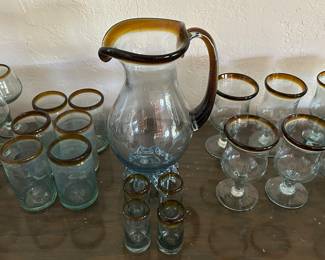 Hand blown pitcher and glasses with amber rim. 