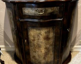 Unique demi-style 3 door cabinet with antiqued accents.