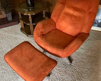 Mid-century modern orange swivel accent chair with ottoman.