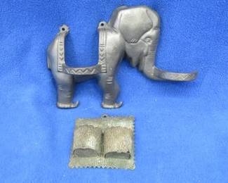 Lot 274. Cast iron or pot metal elephant candle holder of unknown age and an old tin two-place candle holder