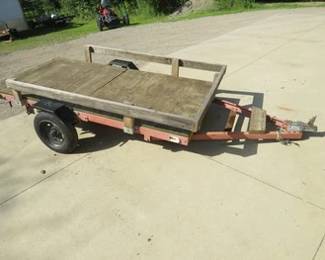 Lot 57. Tilt-bed utility stake bed trailer. 8' x 4' bed of 3/4" plywood. Permanent license. Newer tires. 1 7/8" hitch. No title.