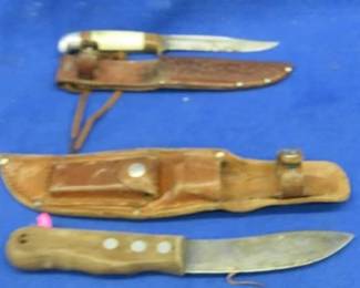 Lot 239. Western 4 1/4" fixed blade knife with a leather sheath, and an unmarked 5" blade and leather sheath with a sharpening stone