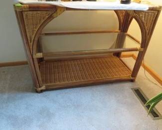 Lot 135. Wicker and glass side table 40"W x 28"H x 18"D Items on table not included