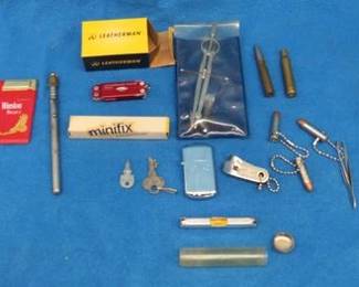 Lot 158. Collectible smalls including bullet keychains, Stanley string level, Micra Leatherman, old tins, hand sickles, and more