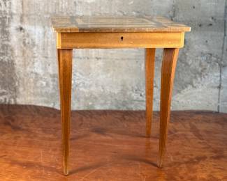 This lot features an Italian inlaid marquetry florentine music box side table in working condition. The legs are a bit loose, but is complete. This piece measures, 17” H x 14.5” W x 10.5” D.