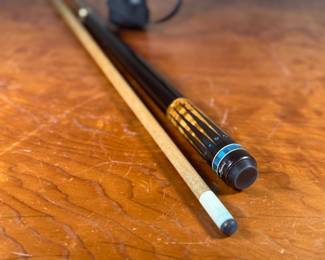 This lot features a Meucci pool cue and case that appears to be in like-new, excellent condition. Meucci Pool Cues, established in 1975, is known for its high-quality, innovative, and aesthetically pleasing pool cues. Bob Meucci, the founder, is credited with significant advancements in cue design and manufacturing, with his cues often used by professional players. The company is recognized for its use of exotic woods, premium metals, and cutting-edge technologies in cue construction.