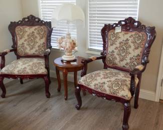 Tuscany style carved chair pair with tapestry upholstery covered both front an back....Ostentatious cherub lamp pair...on small 20 inch carved leg table...cute