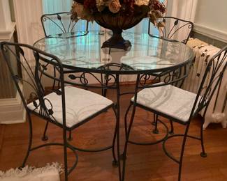 Round glass top wrought iron dining table with 4 matching chairs.