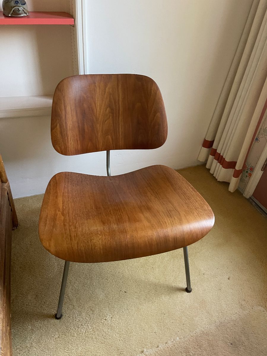 Eames Chair - original authentic
This is an Eames Molded Plywood Lounge Chair with a Metal Base, or an LCM Chair, initially designed by Charles and Ray Eames in 1946. This particular piece was produced by Herman Miller in the USA in 1952. It features a molded five-ply bent wood seat and back with a walnut veneer, and has chromed-steel tubular legs. It retains its original rubber shock mounts to prevent jarring movements.
This chair measures 24.25 inches deep, 22.25 inches wide, and 26.5 inches high. It has a seat height of 15.5 inches. The front panel has some veneer chips on it, and there is a mark on the seat panel. There is slight pitting and patina on the metal frame. We have intentionally left this piece in untouched condition. Overall, this chair is in good condition with some signs of use.