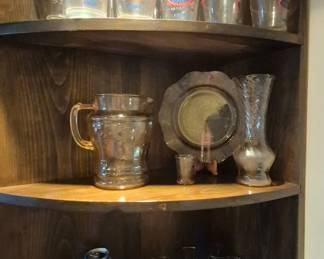 Collectible glassware, pink depression on middle shelf.