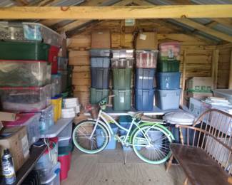 LARGE shed filled with many items: bike cruiser, fabric, blankets, holiday decor, craft supplies