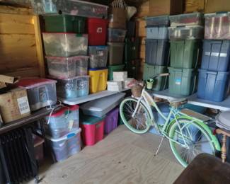 LARGE shed filled with many items: bike cruiser, fabric, blankets, holiday decor, craft supplies