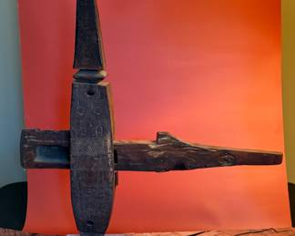 An antique African lock, made of wood, mounted on a stand