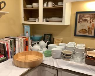 Cook book, wooden salad set, soup bowls of many styles, blue Pyrex bowl.