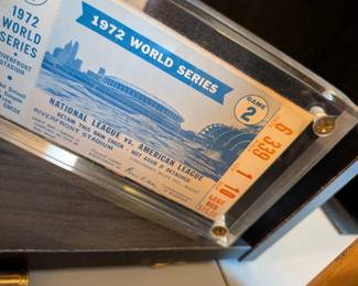 A remarkable and historic collectible! This is a full, intact ticket from Game 2 of the 1972 World Series, a pivotal series that saw the Oakland A's begin their dynasty. The ticket features a beautiful design with an image of Riverfront Stadium and is a fantastic piece of baseball and Americana history. It is a perfect addition for any collector of sports history or World Series memorabilia.