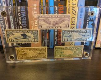 A stunning display for any aviation or stamp enthusiast, this framed collection features six vintage US Air Mail stamps. Issued in the 1920s and 1930s, these stamps showcase iconic themes of early airmail, including a winged globe, mail planes, and maps. The stamps are beautifully preserved in a clear acrylic frame, creating a unique and elegant piece of decorative history.