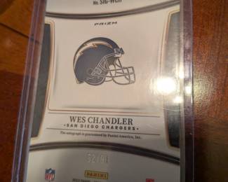 This is a rare, limited edition collectible featuring an authentic signature from former NFL player Wes Chandler. The card is from the Panini Select Prizm set and is numbered 52/99. The autograph is guaranteed by Panini America.