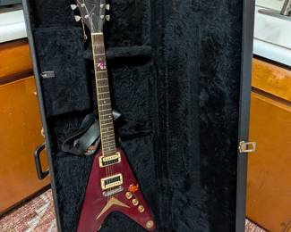 A classic electric guitar for any rock or metal fan! This is an iconic V-shaped guitar by the well-known American manufacturer Dean. The guitar has a rich, deep red finish and comes with a durable, form-fitting hard case. It is in used but functional condition, ready for a musician to tune it up and play. A great find for a collector, a new player, or a professional looking for a reliable stage guitar.