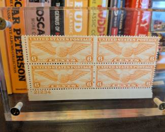 This is a fantastic piece of vintage Americana and philatelic art. The clear acrylic frame beautifully showcases a complete block of four 6-cent "Winged Globe" US Air Mail stamps from 1934. These stamps are a great nod to the history of aviation and the US Postal Service, making this a perfect decorative piece for a home office, study, or for a collector of stamps or aviation memorabilia.