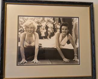 A truly iconic piece of Hollywood history! This framed, black-and-white photo captures the legendary Marilyn Monroe and Jane Russell during their famous handprint ceremony at Grauman's Chinese Theatre. This is a classic image from the Golden Age of Hollywood, perfect for any movie lover or fan of these two timeless stars. It's beautifully presented in a high-quality frame, ready to hang.