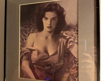 Framed black-and-white photo with a signature that appears to be from Jane Russell, a legendary actress and pin-up model.