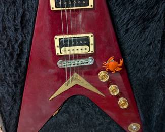 A classic electric guitar for any rock or metal fan! This is an iconic V-shaped guitar by the well-known American manufacturer Dean. The guitar has a rich, deep red finish and comes with a durable, form-fitting hard case. It is in used but functional condition, ready for a musician to tune it up and play. A great find for a collector, a new player, or a professional looking for a reliable stage guitar.