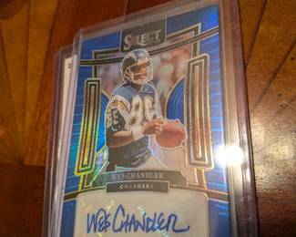 This is a rare, limited edition collectible featuring an authentic signature from former NFL player Wes Chandler. The card is from the Panini Select Prizm set and is numbered 52/99. The autograph is guaranteed by Panini America.