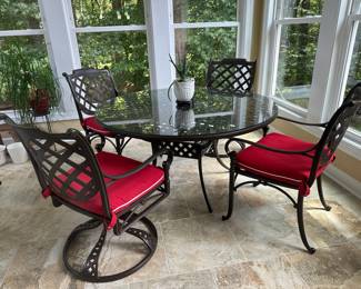 Like-new bronze metal, 53" round glass-top table with 2 stationery chairs and 2 swivel chairs with red cushions
