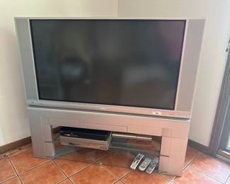 Hitachi 50" rear projection TV with stand, remote controls, and built-in speakers.
