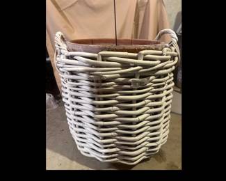 Large woven white wicker planter with handles and interior terracotta pot.