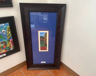 Colorful folk art print in oversized dark wood frame with bright blue mat.