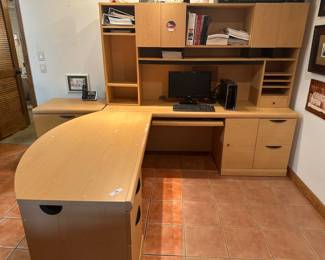 Large L-shaped light wood modular office desk with drawers, hutch, and computer shelf.