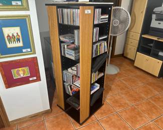 Wooden media tower filled with assorted CDs.