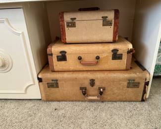 Three vintage suitcases are clean inside and two have inner trays